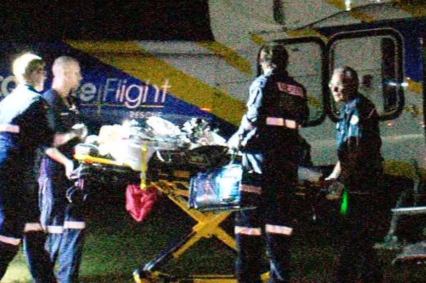 A stretcher with one of the injured boys being put in a helicopter by paramedics.