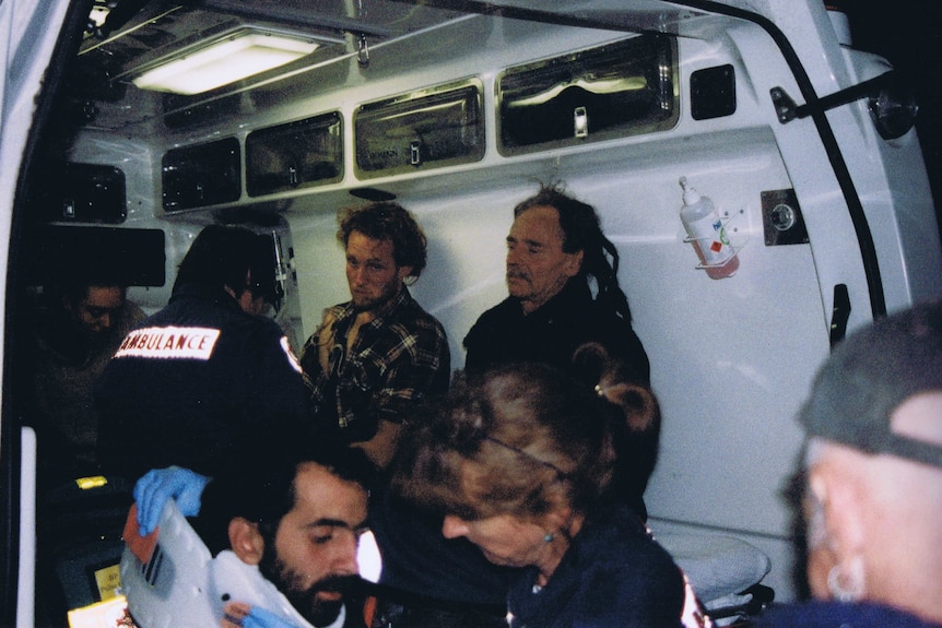 Protesters and ambulance officers in an ambulance.