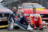 Shane van Gisbergen and Scott McLaughlin sit in front of two Supercars on a track.