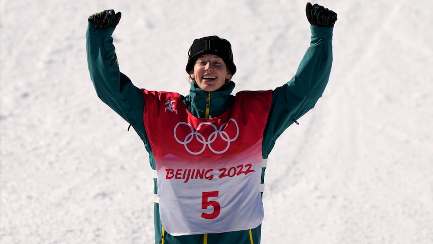Australian Winter Olympics bronze medallist Tess Coady smiles and raises her arm in triumph after her event in Beijing.