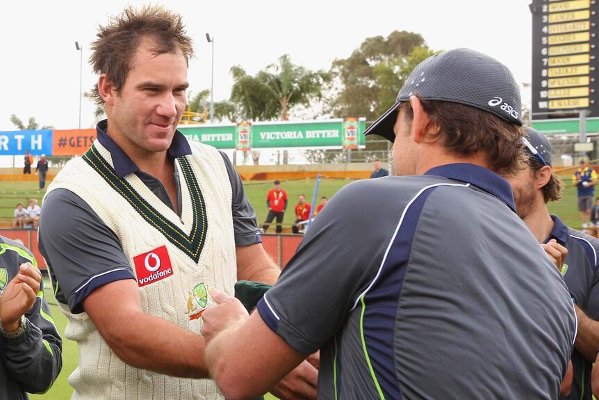 On debut... John Hastings is presented with his baggy green by Adam Gilchrist.