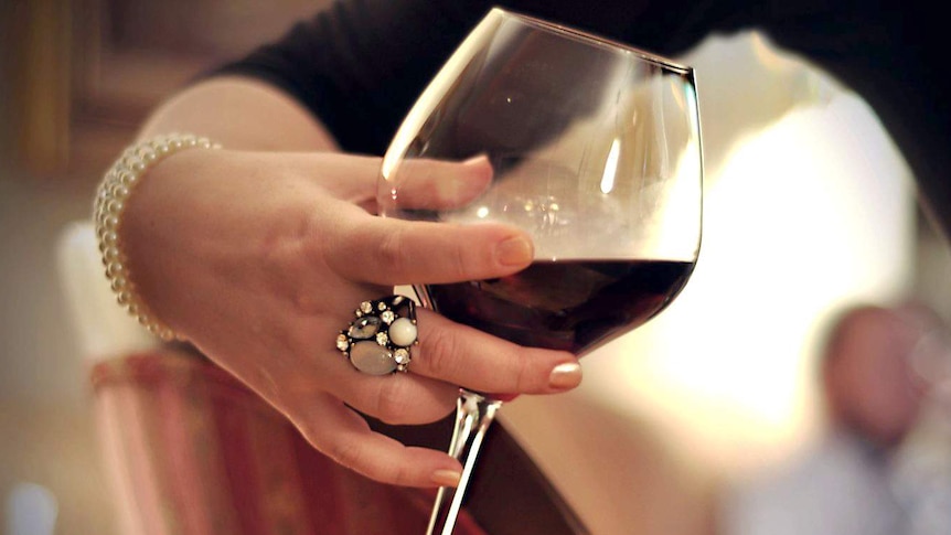 Woman holds glass of wine