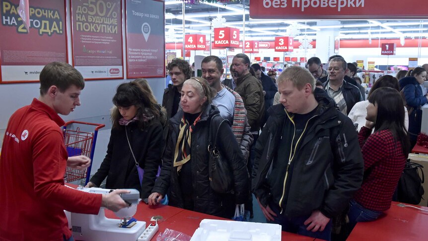 People wait in line in a mall in central Moscow