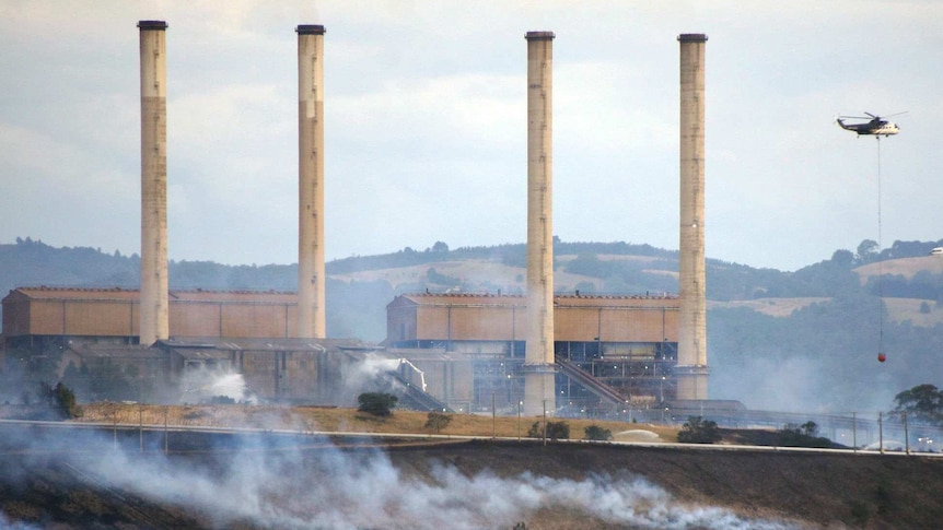 Hazelwood power station with helicopter dropping water on fire nearby.