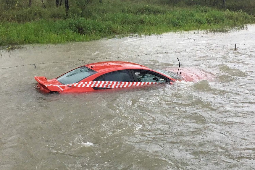 Car submerged in floodwaters on side of a road in Townsville in north Queensland on March 1, 2018.