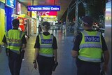 Four Victoria Police Officers walking away  down street
