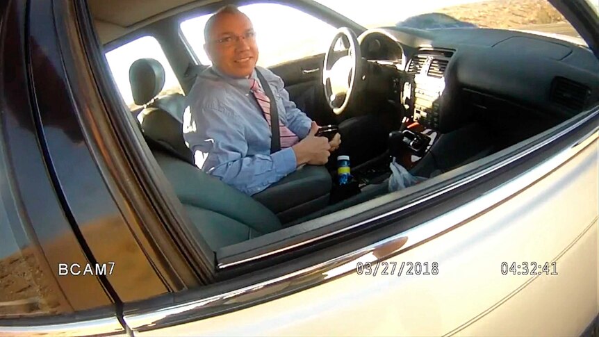 Mr Mosley smiles in his car in screenshot from police body camera footage