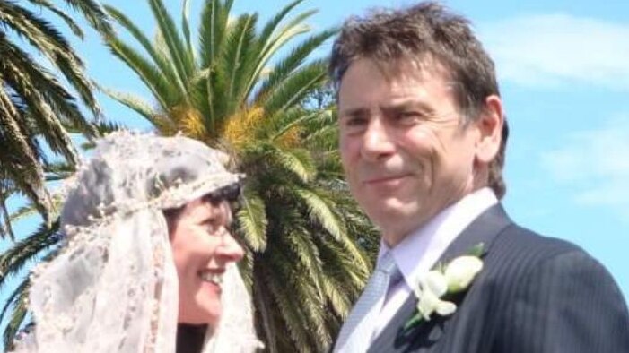 A middle aged man outside in suit at a wedding