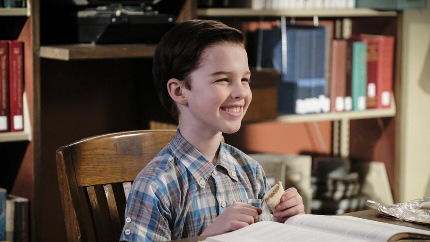 A scene from Young Sheldon with star Iain Armitage reading a book