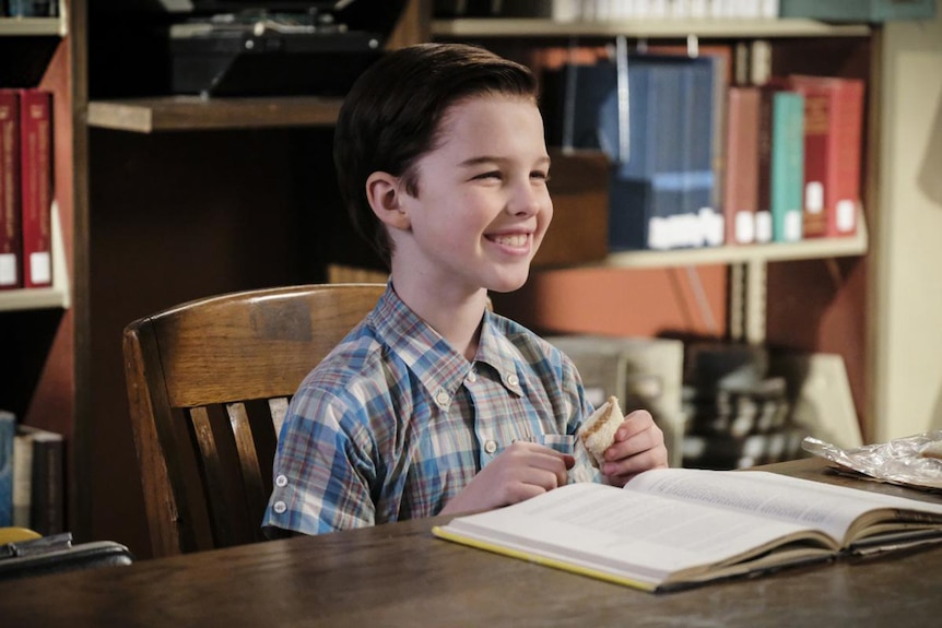 A scene from Young Sheldon with star Iain Armitage reading a book