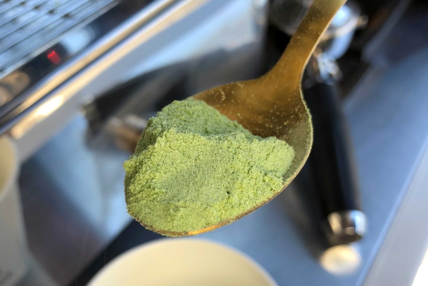 A small spoon, heaped with green powder