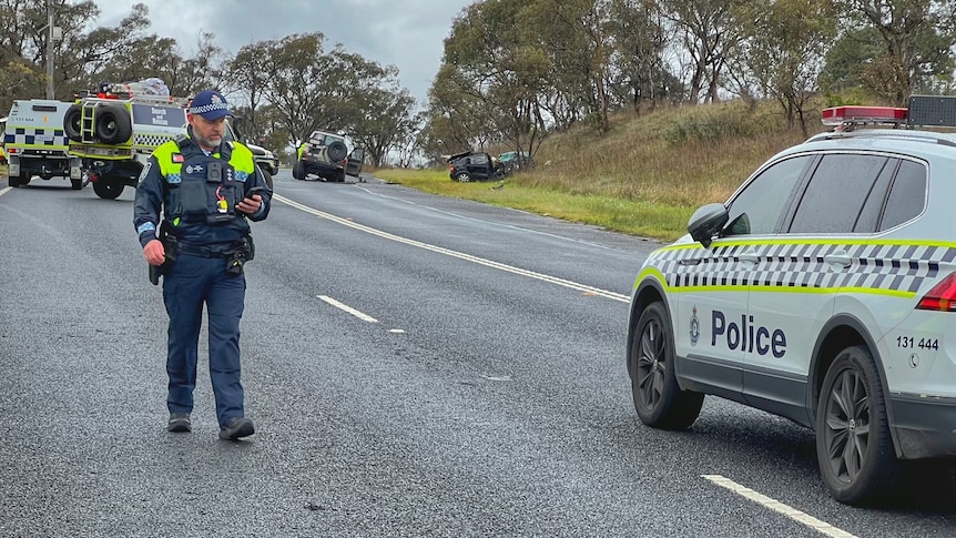 A police officer walking away from a car crash in Canberra.