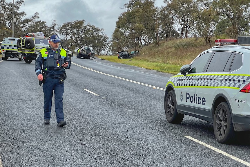 A police officer walking away from a car crash in Canberra.