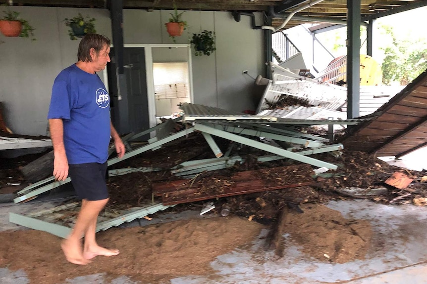 Resident Roger Goodwin looks at damage his flooded-ravaged home at Bluewater.