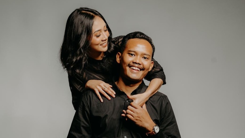 A photograph of an Indonesian husband and wife both wearing black.