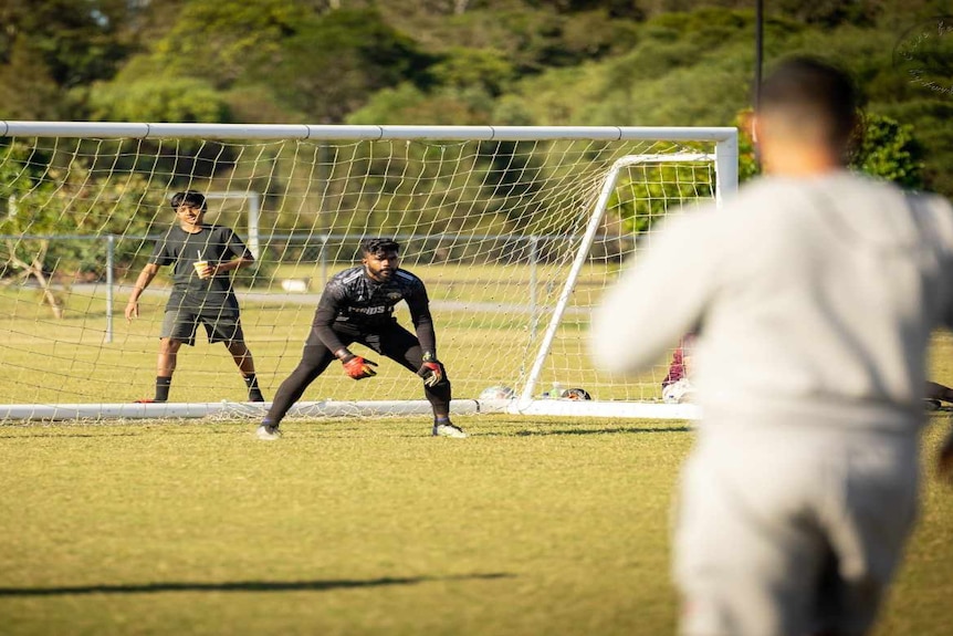 Man in black sports gear inside soccer goal