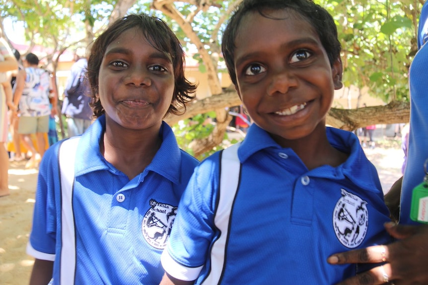 Yirrkala school children wear blue uniforms smiling.