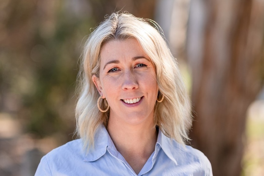 A woman with blonde hair wearing a blue shirt