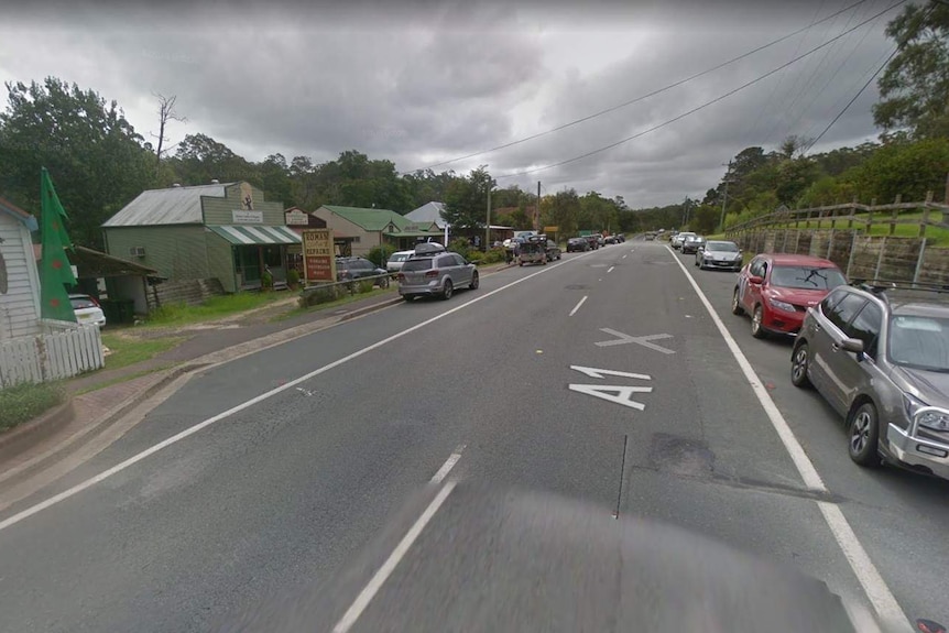 The main street lined with shops and parked cars in Mogo