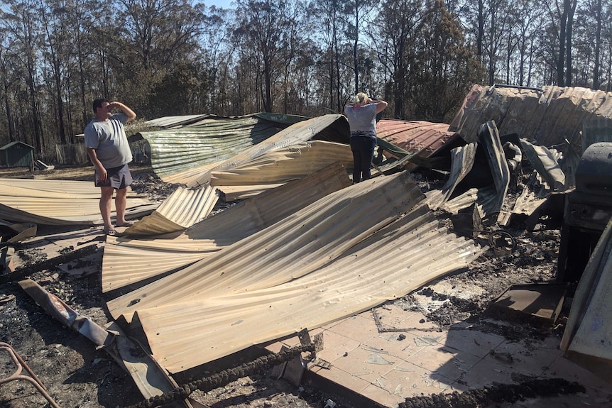 Angelo and Chantal Fornasier standing in the burnt our rubble of the home after it was destroyed by a bushfire