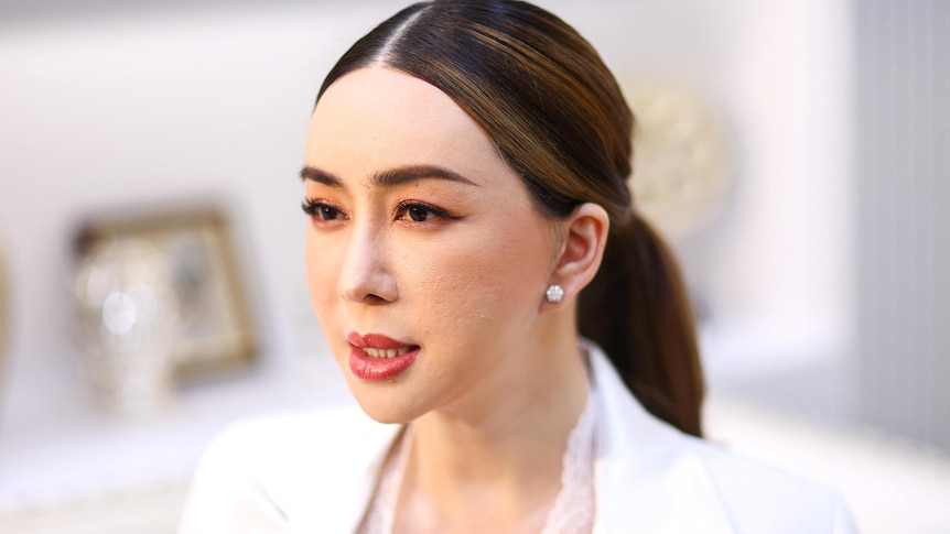 A woman dressed in white looks away from the camera