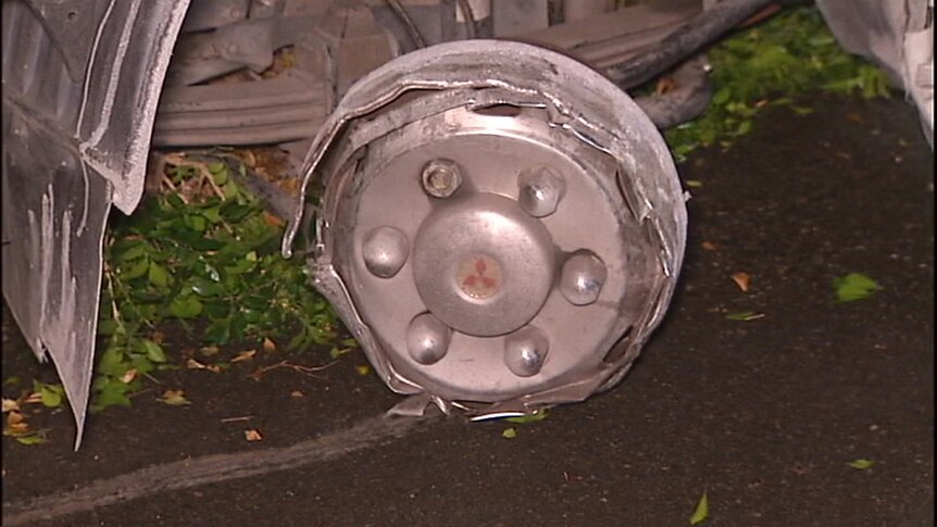 A wheel of a car with no tyre, blown out by a tyre deflation device.