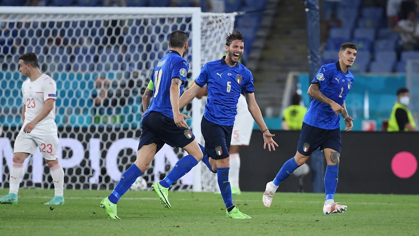 Italy's Manuel Locatelli runs away from goal with his mouth open in celebration after scoring at Euro 2020. 