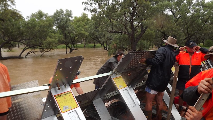 Men in Charleville assemble a levee to hold back the flooding Warrego River.