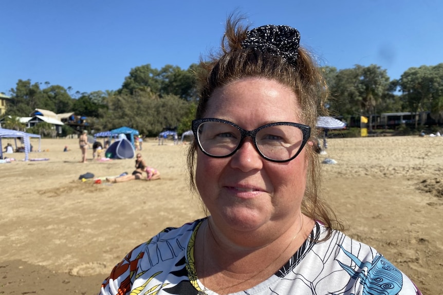 A woman with glasses on a beach