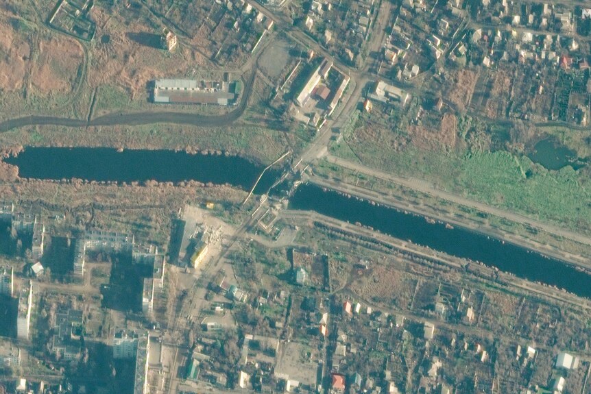 An image from above of a damaged bridge over a body of water. 