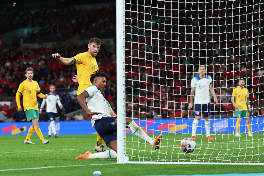 England's Ollie Watkins slides in to score a goal against the Socceroos.