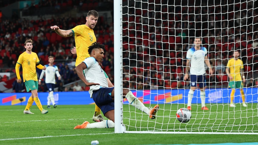 England's Ollie Watkins slides in to score a goal against the Socceroos.