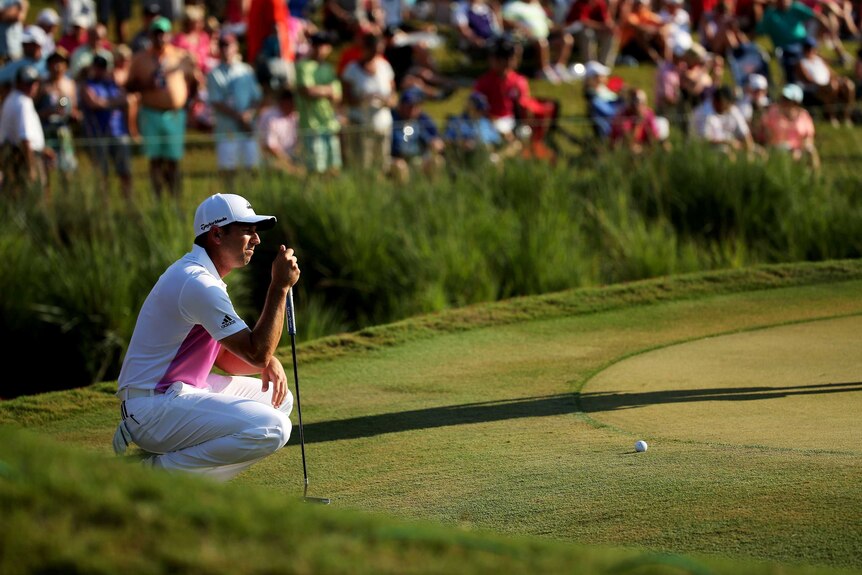 Sergio Garcia examines the green at the Players Championship