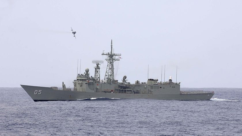 A Hawk trainer jet passes fast and low over HMAS Melbourne (Australian Defence Force)