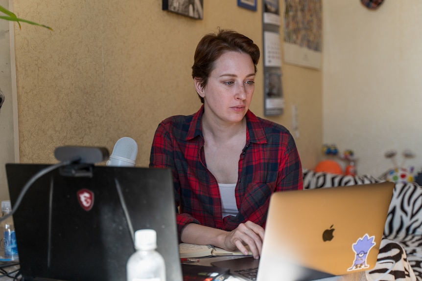 Tatyana at her computer with a microphone.