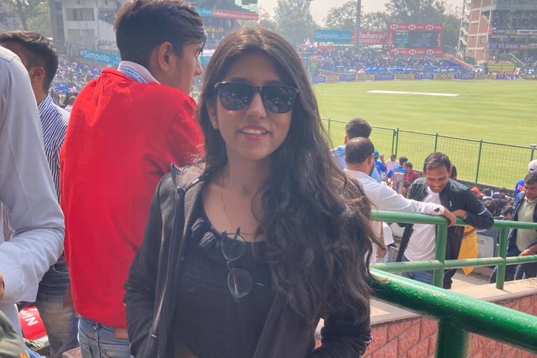 Jahanvi Goyal poses for a photo in the grandstand while watching an India V Australia Test match.