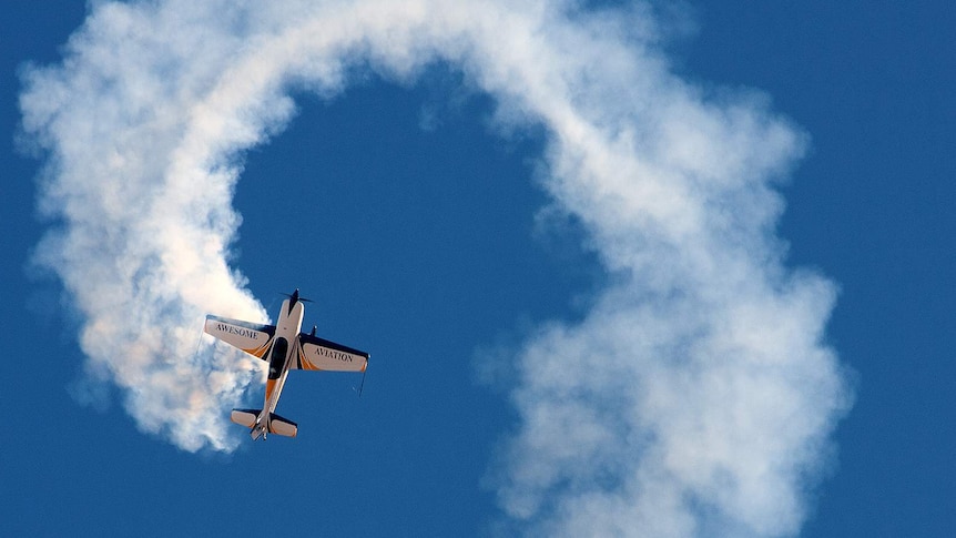 A plane leaves a smoke trail while it flies in a loop