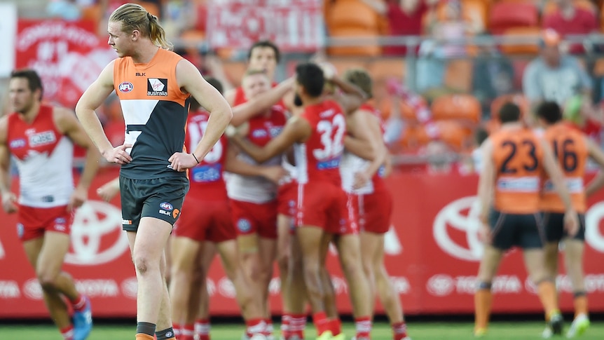 The Giants' Cam McCarthy watches on, dejected as the Swans score a goal on August 22, 2015.
