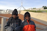 Two Aboriginal boys in front of Parliament House in Canberra.