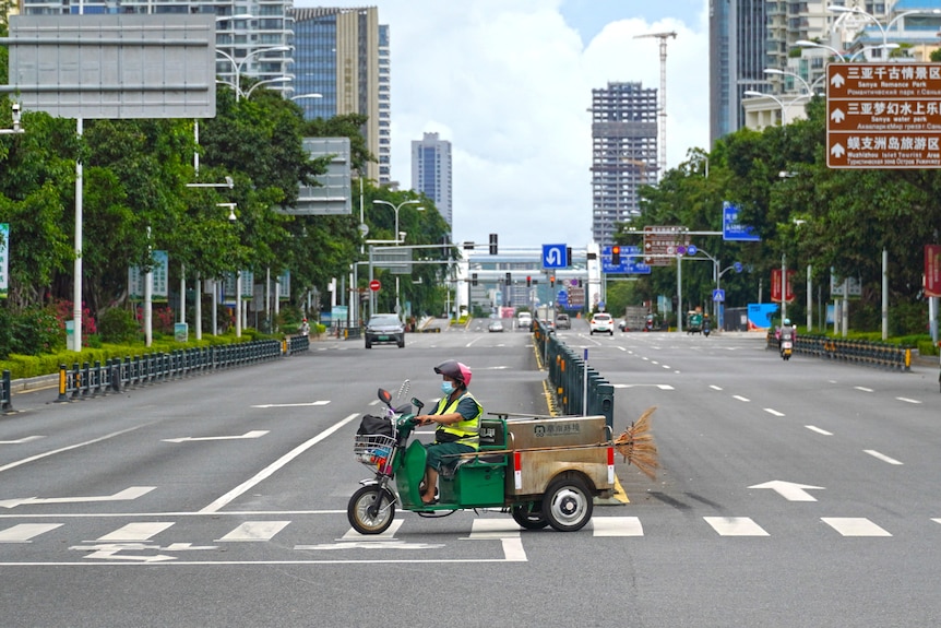 A sanitation worker drives past an intersection amid lockdown measures to curb the coronavirus disease.