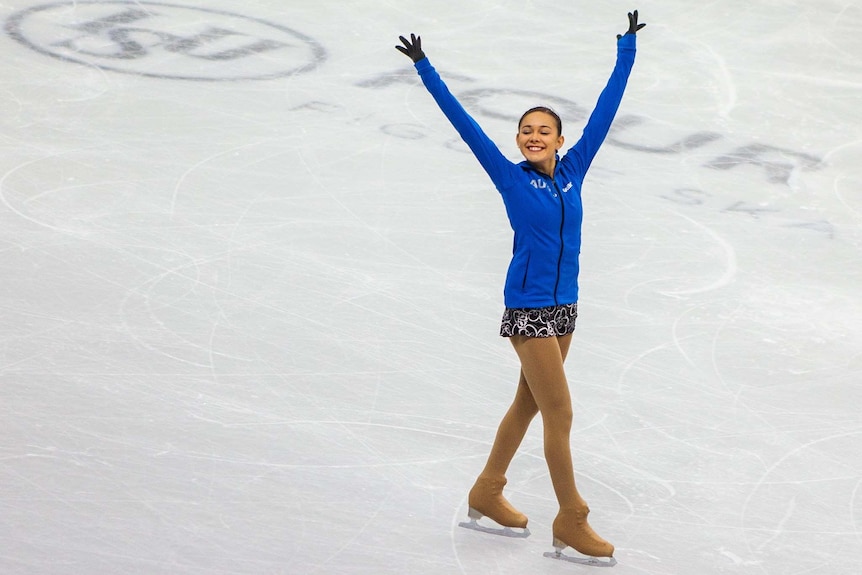 Kailani Craine smiles while skating on an ice rink.