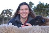 Rachel O’Brien hand feeds two sheep.
