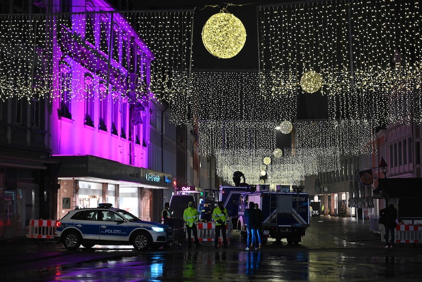 Christmas lights hang above police officers gathered in the German city of Trier.