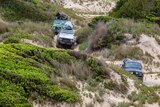 Three vehicles make drive on a track on Tasmania's west coast