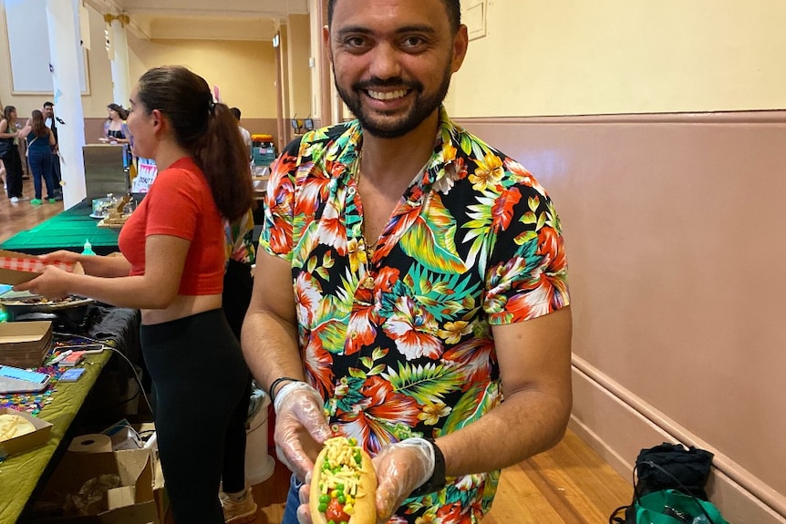 A man in a colourful shirt serves food