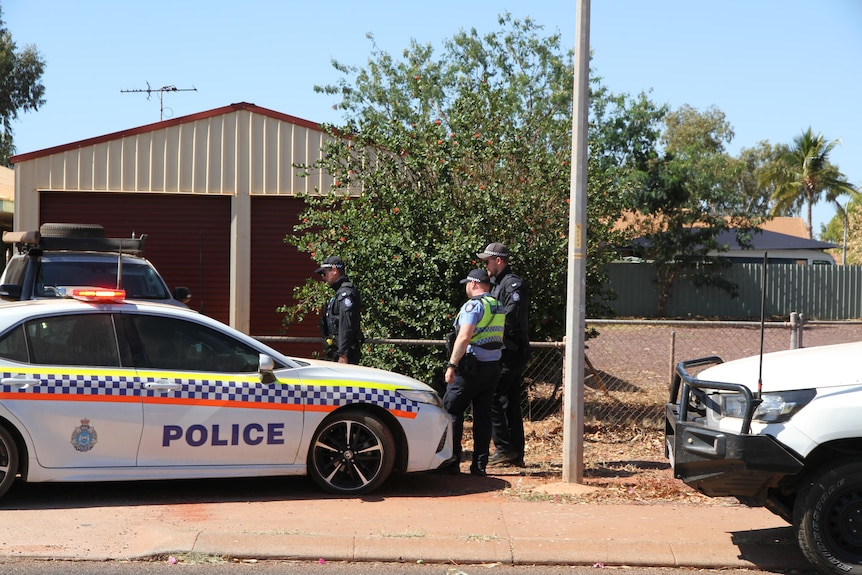 Police officers and vehicles outside of a crime scene