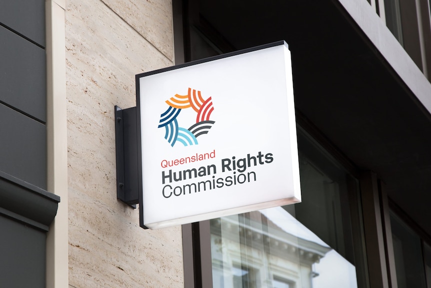 Sign on stone wall with Queensland Human Rights Commission logo