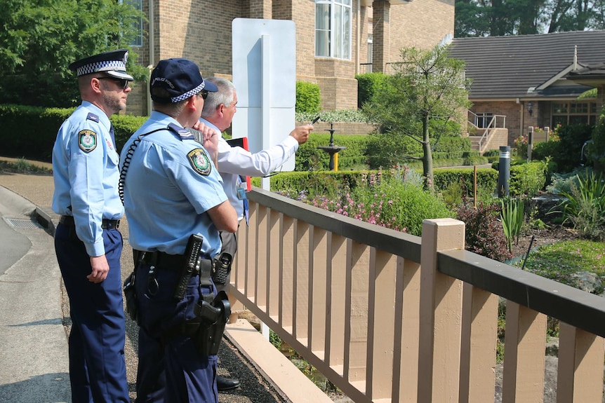 Two police officers chat to a man at a retirement village.