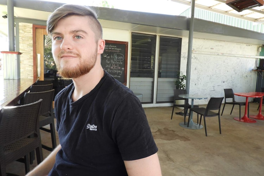 Young man stands in outdoor area