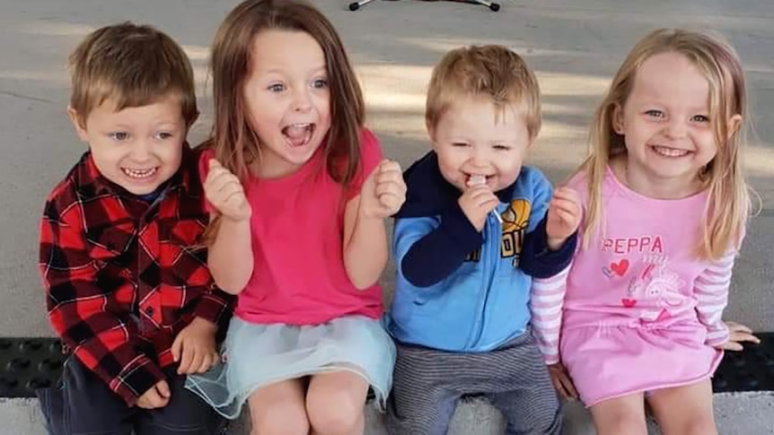 Four young children smiling and laughing